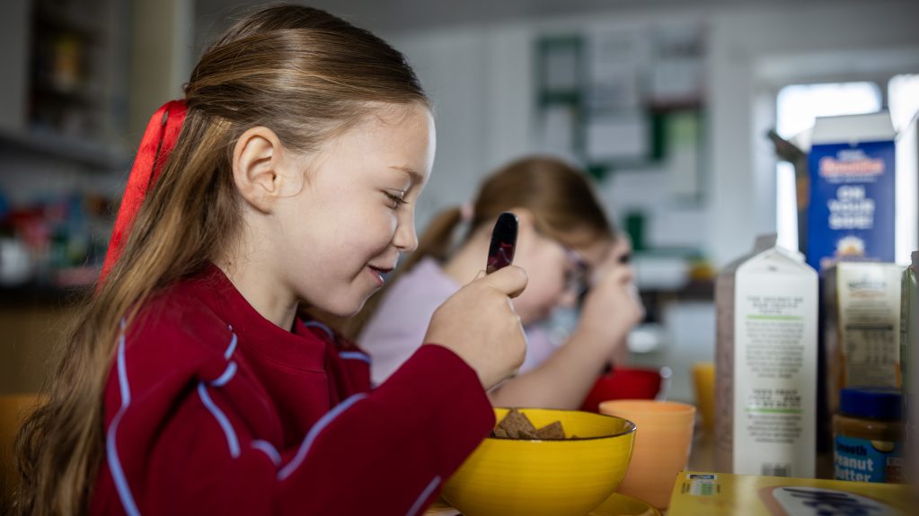 Girl eating from bowl of cereal
