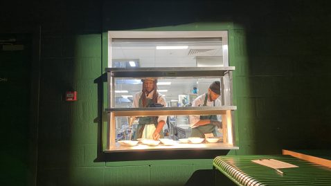 Two chefs plating up food in the kitchen
