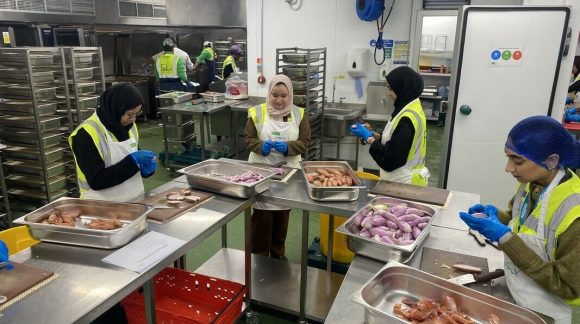 Group of woman preparing vegetables in industrial kitchen