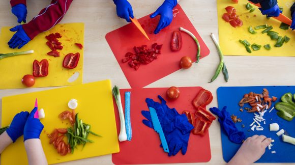 Six colourful chopping boards with children chopping vegetables