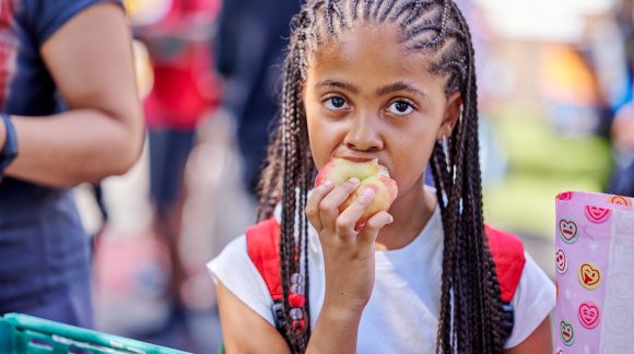 Young girl taking a bite from an apple