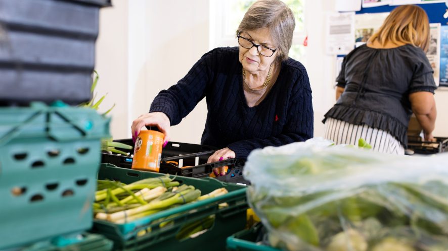 Woman placing can of food into a box of food