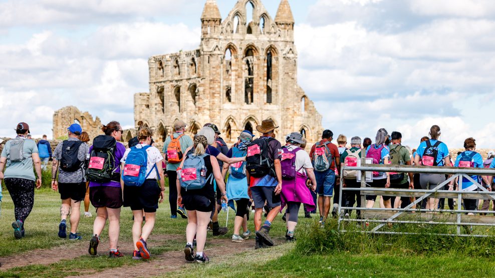 Big group of people walking in front of Whitby Abbey