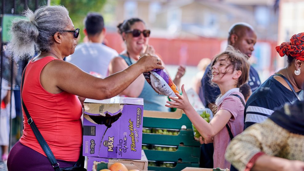Woman handing bag of food to young girl